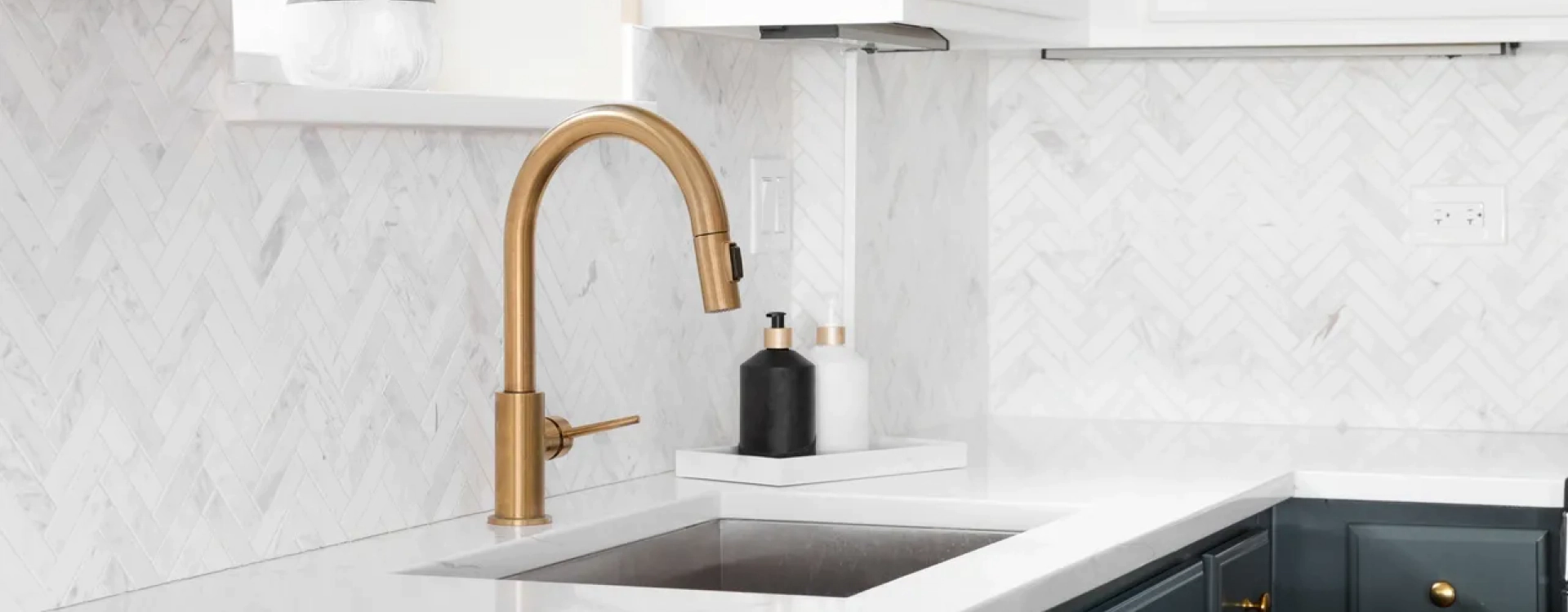 white kitchen sink with a golden faucet
